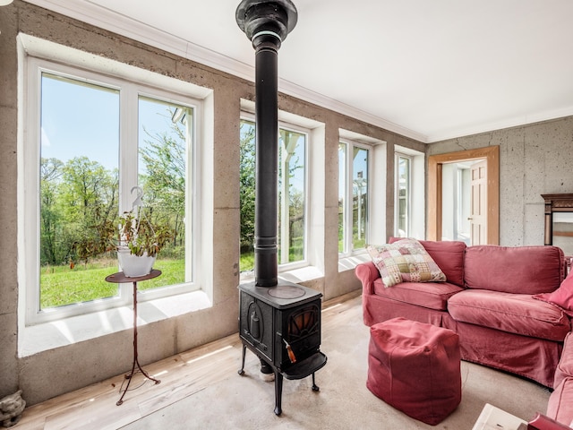 sunroom with plenty of natural light and a wood stove