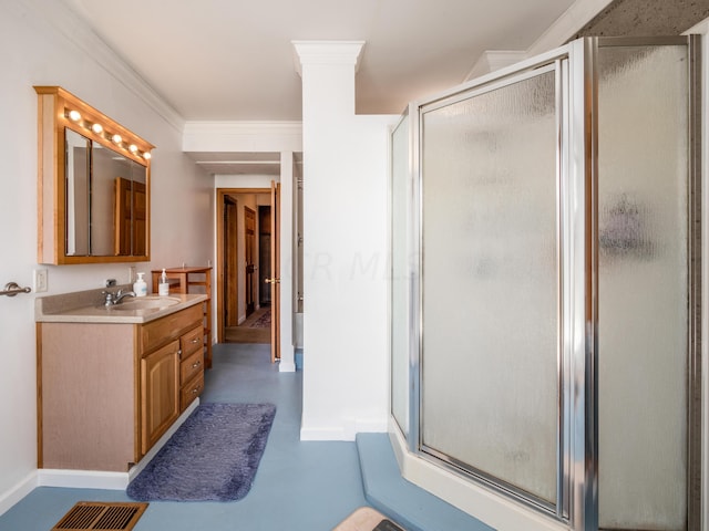 bathroom with vanity, an enclosed shower, and crown molding