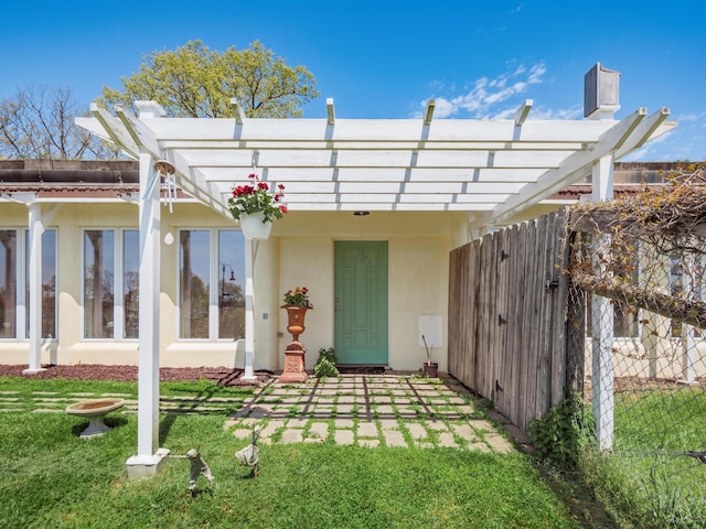 back of house featuring a lawn and a pergola