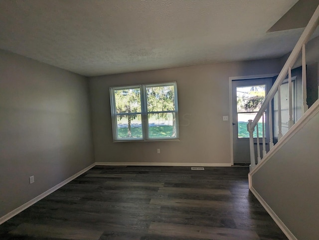 interior space with plenty of natural light, dark hardwood / wood-style flooring, and a textured ceiling