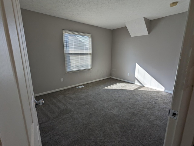 carpeted spare room featuring a textured ceiling