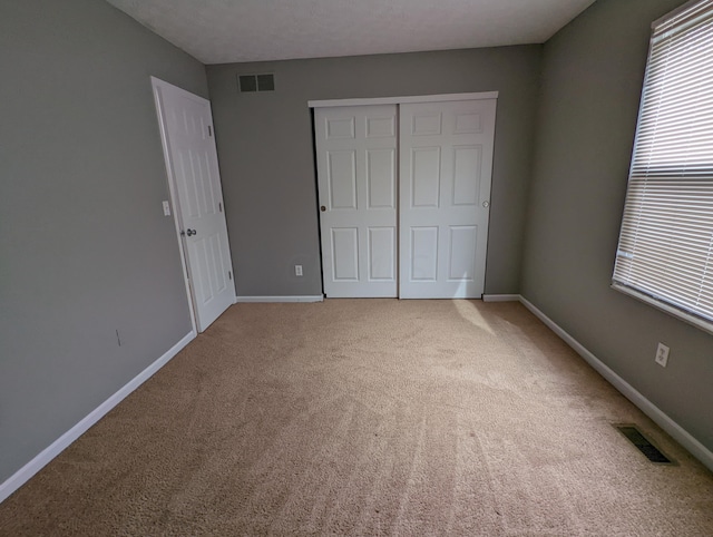 unfurnished bedroom with carpet floors and a closet