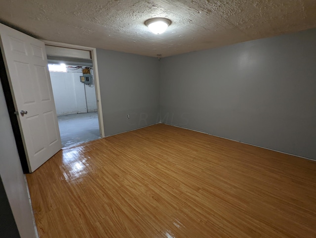 spare room featuring a textured ceiling and hardwood / wood-style flooring