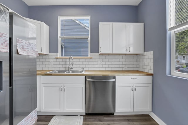 kitchen featuring butcher block counters, sink, dark hardwood / wood-style flooring, white cabinetry, and stainless steel appliances