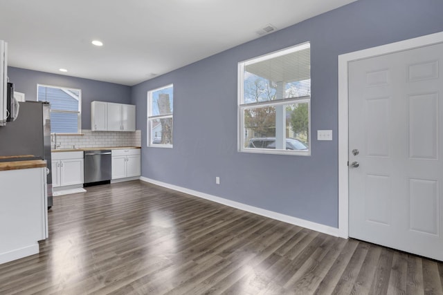 kitchen with white cabinetry, dark hardwood / wood-style flooring, a healthy amount of sunlight, and appliances with stainless steel finishes