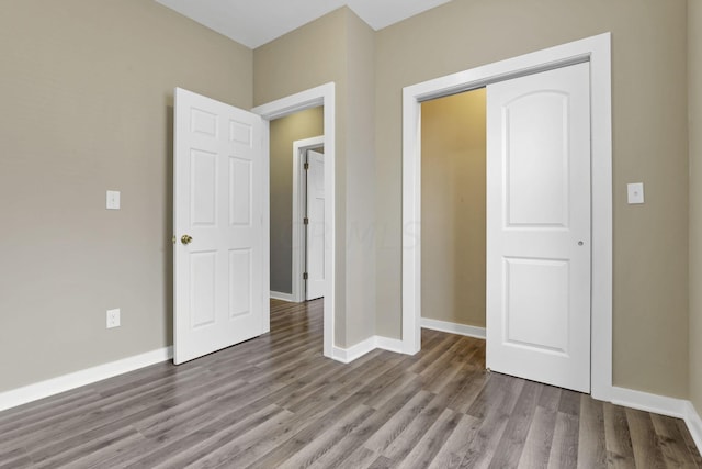 unfurnished bedroom with hardwood / wood-style flooring and a closet