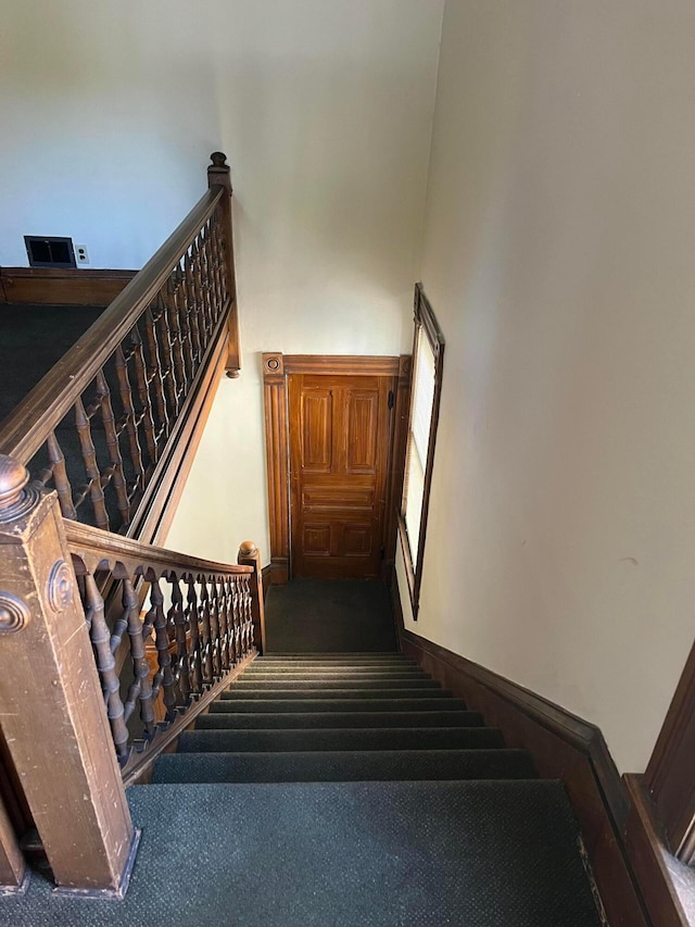 staircase featuring carpet flooring