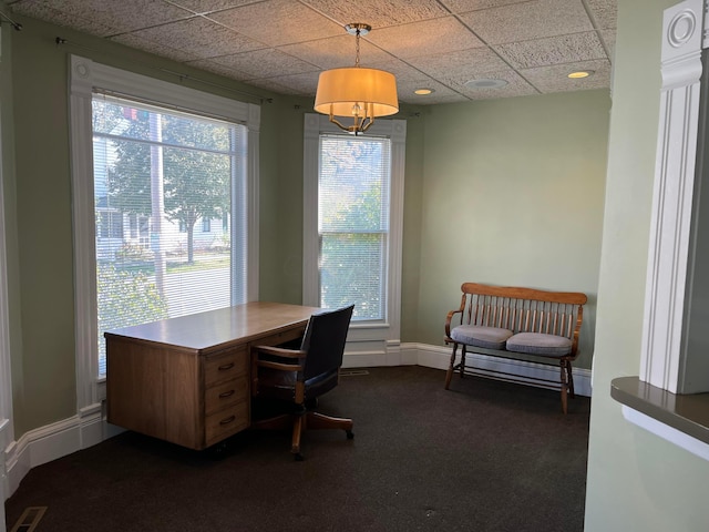 office with dark colored carpet, plenty of natural light, and a drop ceiling