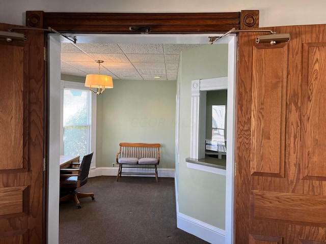 carpeted home office with a drop ceiling