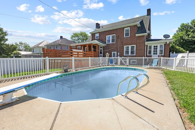 view of swimming pool with a patio and a diving board