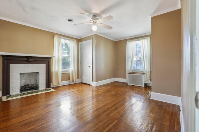 unfurnished living room featuring hardwood / wood-style flooring, ceiling fan, ornamental molding, a fireplace, and radiator heating unit