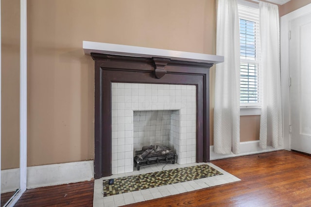 details with hardwood / wood-style floors and a tiled fireplace