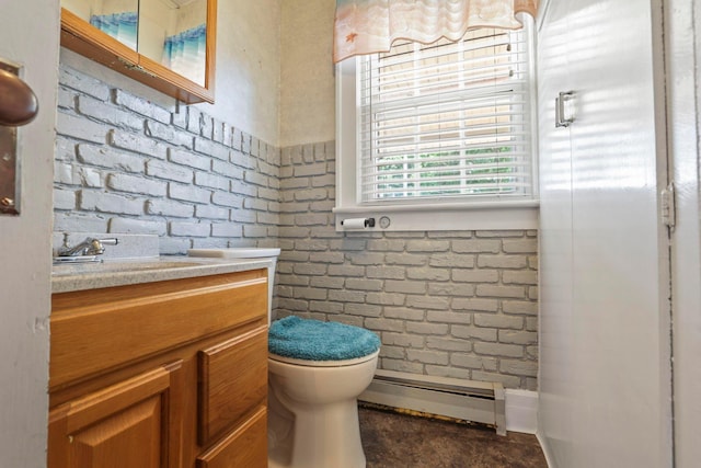 bathroom with vanity, toilet, brick wall, and a baseboard radiator