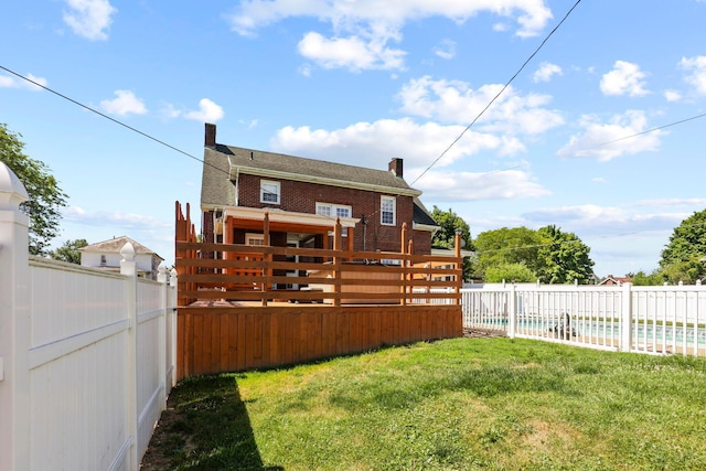 rear view of property with a yard and a wooden deck