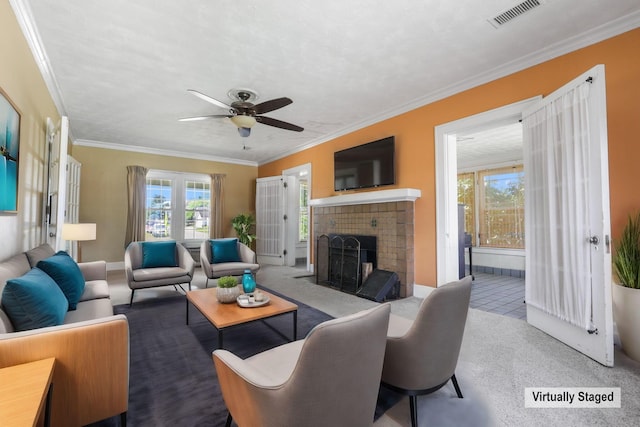 living room featuring a fireplace, light carpet, ceiling fan, and crown molding