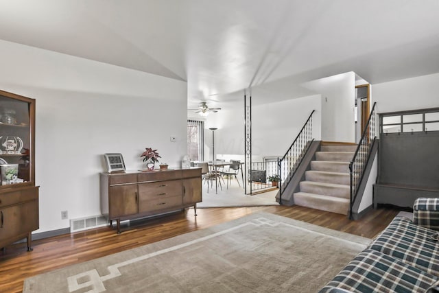 living room featuring ceiling fan and dark wood-type flooring