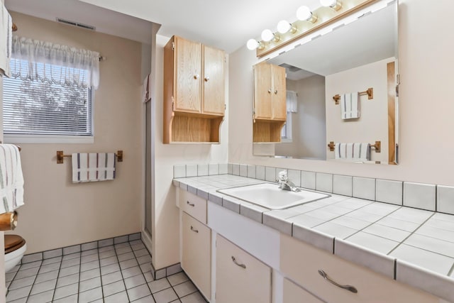 bathroom with tile patterned flooring, vanity, toilet, and a shower with shower door