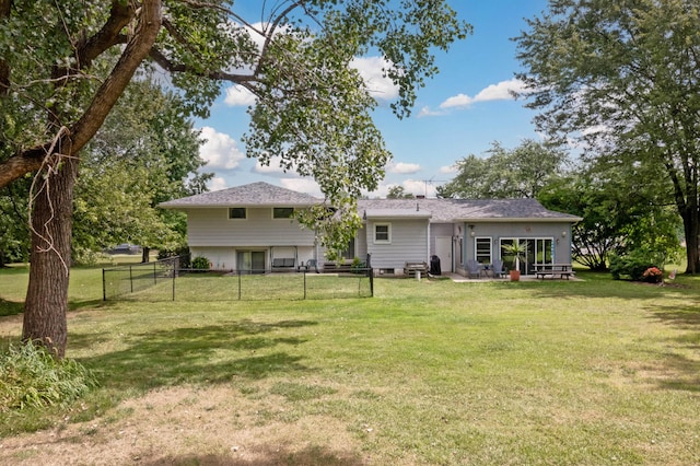 rear view of house with a lawn and a patio