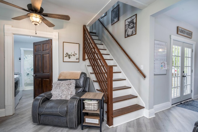 stairs with french doors, ceiling fan, and hardwood / wood-style floors