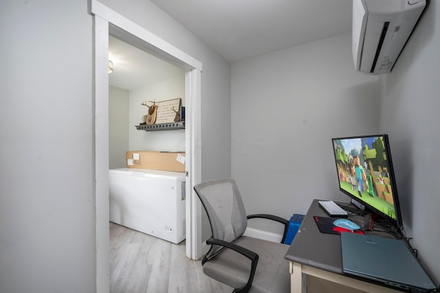 office with a wall mounted AC and light hardwood / wood-style flooring