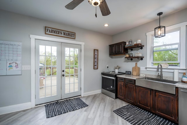 kitchen with a wealth of natural light, sink, hanging light fixtures, and appliances with stainless steel finishes