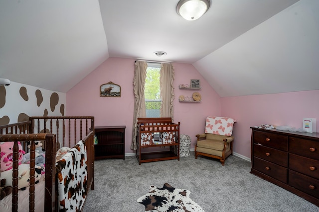 carpeted bedroom featuring vaulted ceiling and a crib