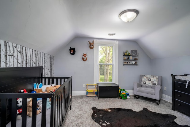 carpeted bedroom featuring a crib and vaulted ceiling