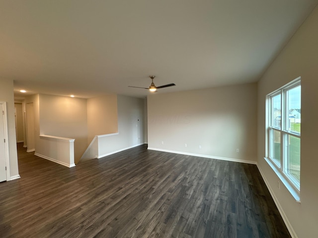 unfurnished living room with dark hardwood / wood-style floors and ceiling fan