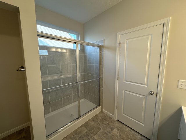 bathroom featuring a shower with shower door