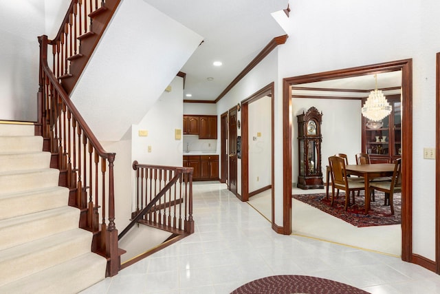 stairway featuring tile patterned flooring, crown molding, and a notable chandelier