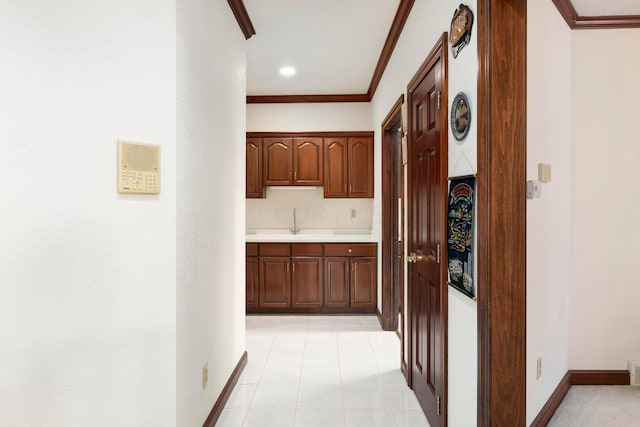 kitchen with sink, light tile patterned flooring, and ornamental molding