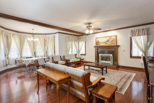 living room with dark hardwood / wood-style flooring, ceiling fan with notable chandelier, a textured ceiling, and ornamental molding