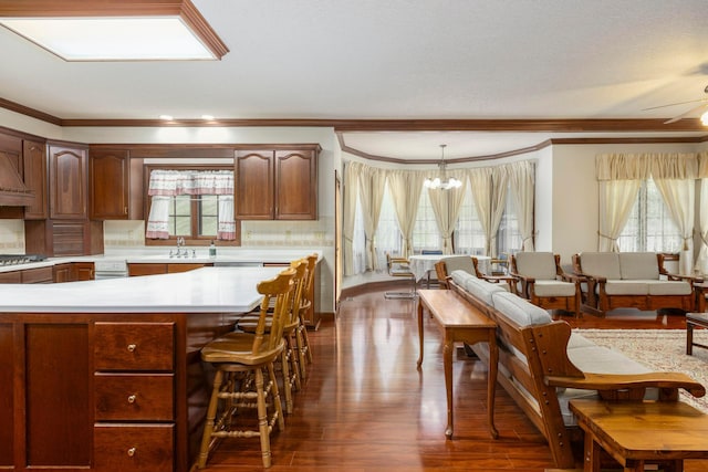 kitchen featuring ceiling fan with notable chandelier, crown molding, decorative backsplash, decorative light fixtures, and dark hardwood / wood-style flooring