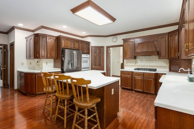 kitchen featuring stainless steel fridge with ice dispenser, dark hardwood / wood-style flooring, a center island, and a kitchen breakfast bar