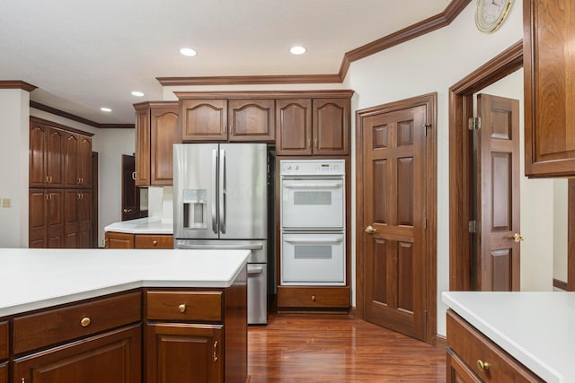 kitchen with dark hardwood / wood-style floors, white double oven, stainless steel fridge with ice dispenser, and crown molding