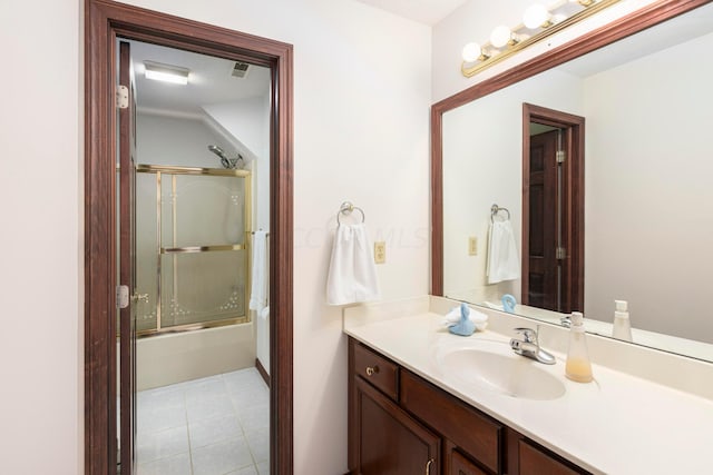 bathroom featuring tile patterned flooring, vanity, and enclosed tub / shower combo