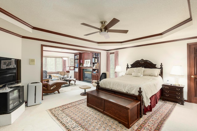 carpeted bedroom with a textured ceiling, ceiling fan, and ornamental molding