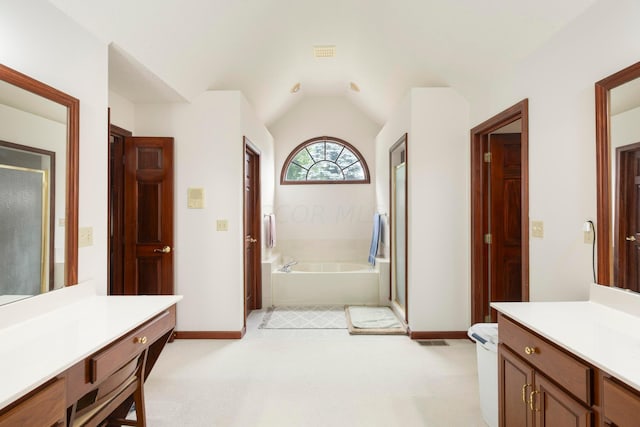 bathroom featuring vanity, a bathtub, and lofted ceiling