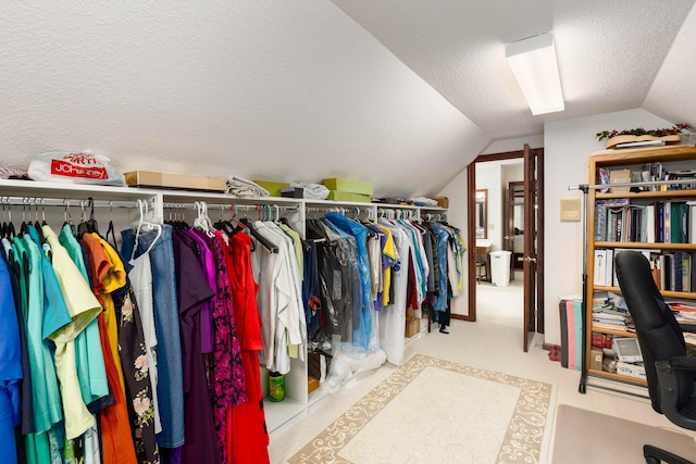 walk in closet featuring light colored carpet and lofted ceiling