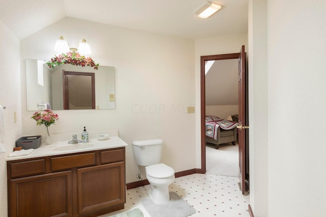 bathroom featuring vanity, lofted ceiling, and toilet