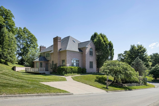 view of front of property with a wooden deck and a front yard