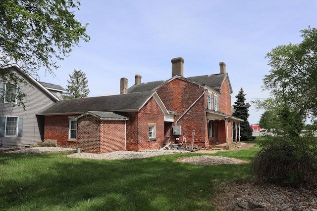 rear view of house featuring a lawn