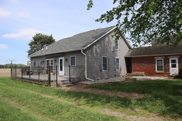 rear view of house featuring a lawn