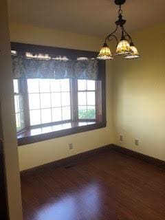 unfurnished dining area featuring dark hardwood / wood-style flooring