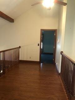 hall with dark hardwood / wood-style flooring, beam ceiling, and high vaulted ceiling