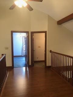 corridor featuring high vaulted ceiling, dark hardwood / wood-style floors, and beamed ceiling