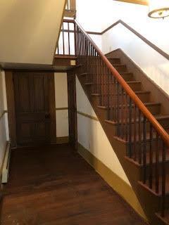 stairway with hardwood / wood-style floors and a baseboard radiator