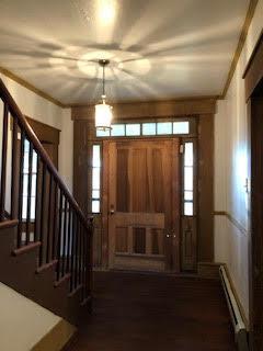 foyer entrance featuring ornamental molding and baseboard heating