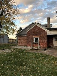 back house at dusk with a yard and a patio