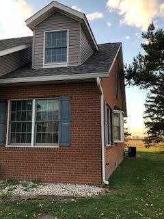 property exterior at dusk featuring a lawn